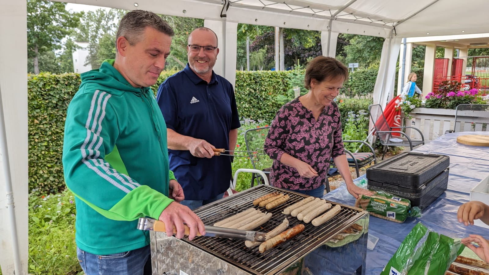Zusammen mit Sonja Skarba-Döring (CDU) und Bürgermeister Ulf Gabriel (SPD) grillt Lars Wedekind (CDU) die Bratwürste bei der Zeugnisparty.